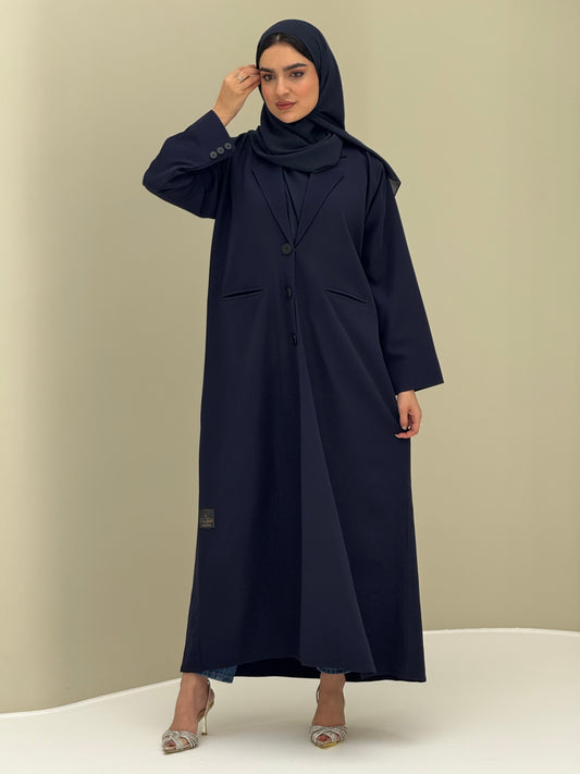 A woman wearing a navy blue Coat style with a lapel collar, Button-front, welt pockets, buttoned cuffs, and a matching sheila