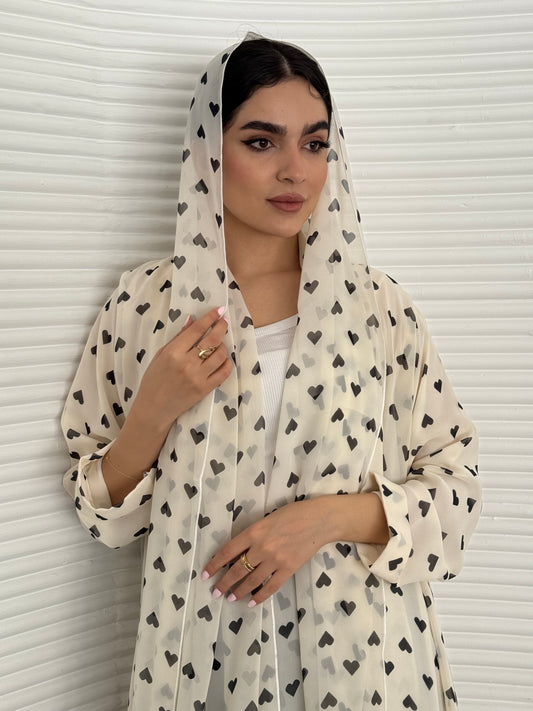 A cream heart print chiffon abaya, an elegant abaya that is perfect for summer, daytime events, and brunch.