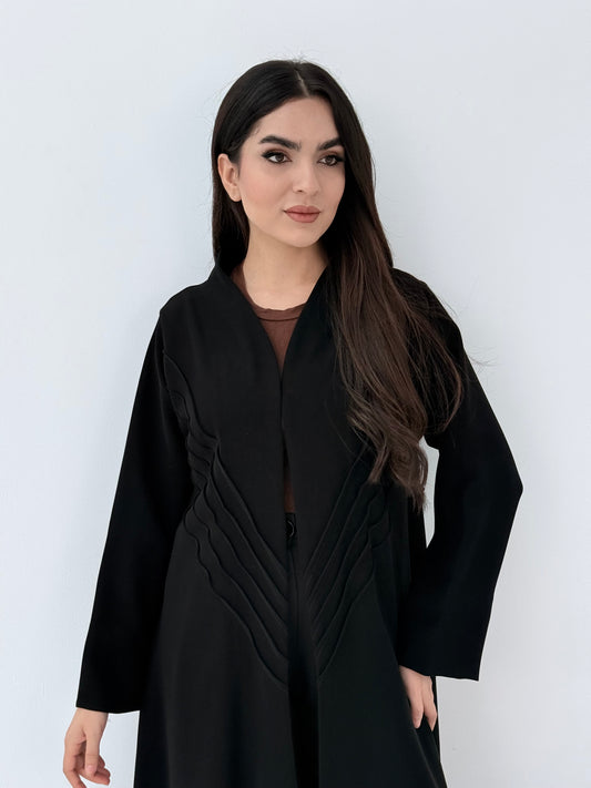 Woman wearing a long Premium black Crepe Abaya with Pleated Waist dress on a white background