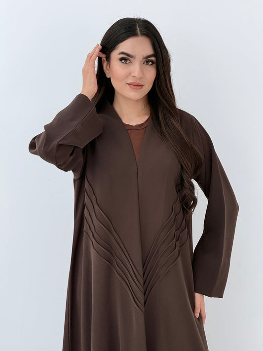 Woman wearing a long Premium dark brown Crepe Abaya with Pleated Waist dress on a white background