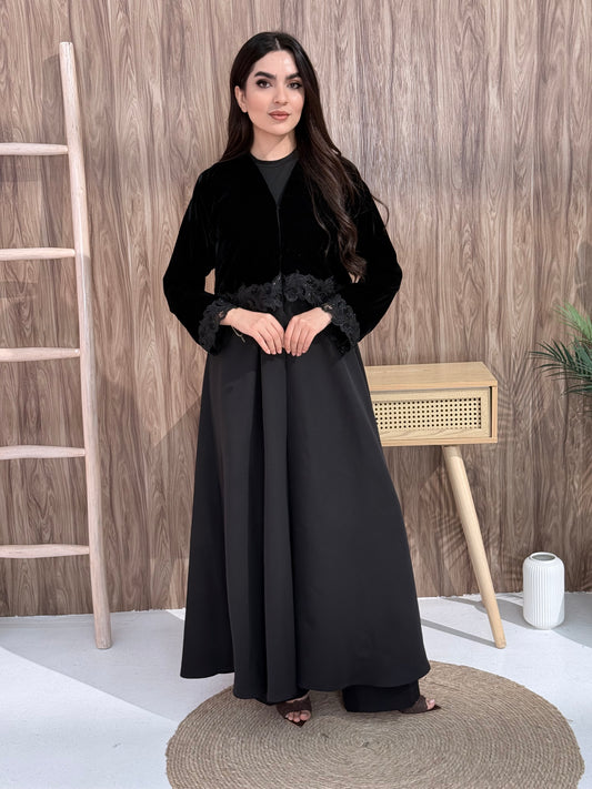 Woman in a Premium black velvet Crepe and Velvet abaya on a wooden background