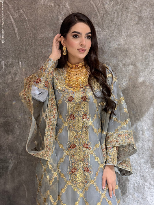 Woman wearing a Grey Luxury Embroidered Kaftan traditional outfit on a textured surface
