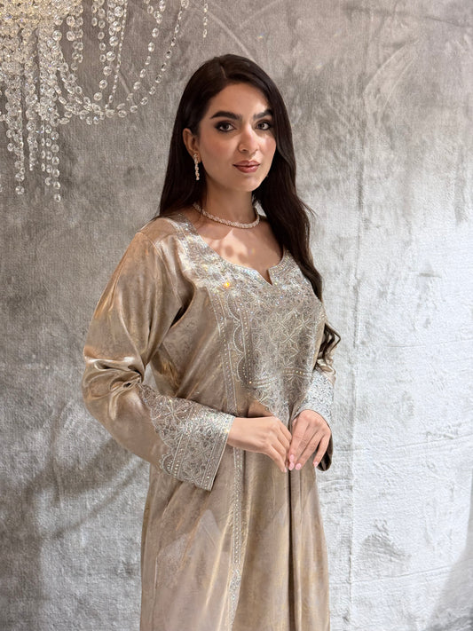Woman in a beige kaftan jalabiya dress standing on a textured surface