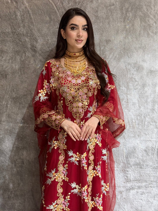Woman wearing a Maroon Luxury Embroidered Kaftan dress on a textured gray background