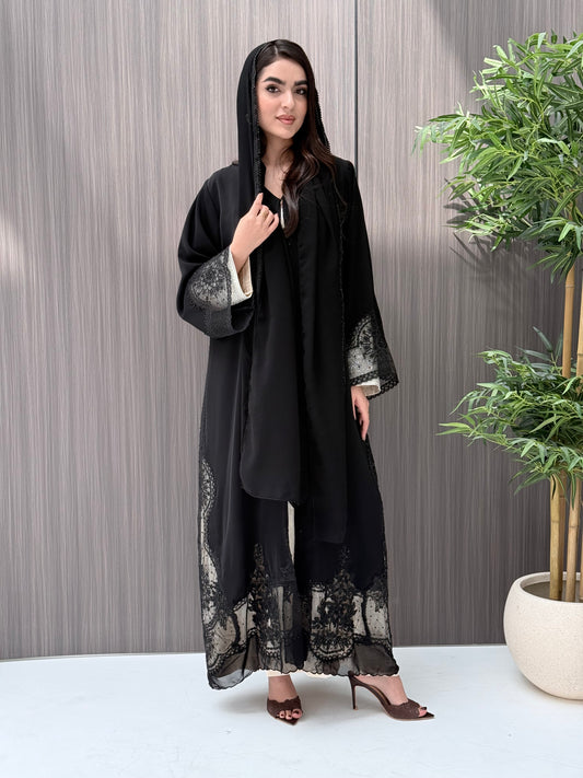 Woman wearing a luxury open-front black abaya crafted from premium Nida fabric with matching sheila on a gray background