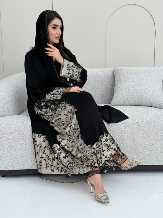 Woman wearing an elegant luxury open-front black abaya crafted from premium Nida fabric with a matching sheila.
on a white background