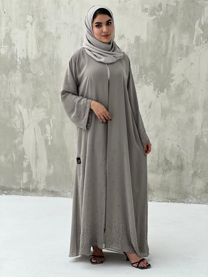 A woman wearing a Grey Chiffon Abaya with Crystal Beads with long sleeves and a matching headscarf.