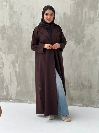 A woman wearing a Dark Brown Coat-Style Abaya with buttons down the front, paired with a matching headscarf.