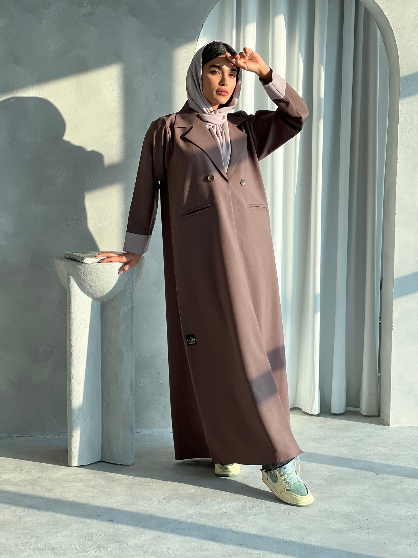 A woman wearing a Cocoa Brown Blazer-Style Abaya with long sleeves and a matching Sheila, standing indoors.