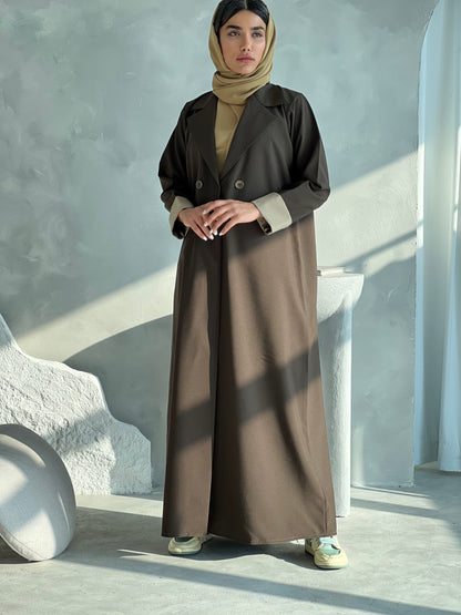A woman wearing a Dark Olive Blazer-Style Abaya with long sleeves and a matching Sheila, standing indoors.