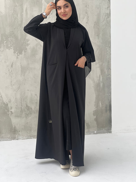 A woman wearing a Black Blazer-Style Abaya with Embroidered Sleeves with a Sheila headscarf.