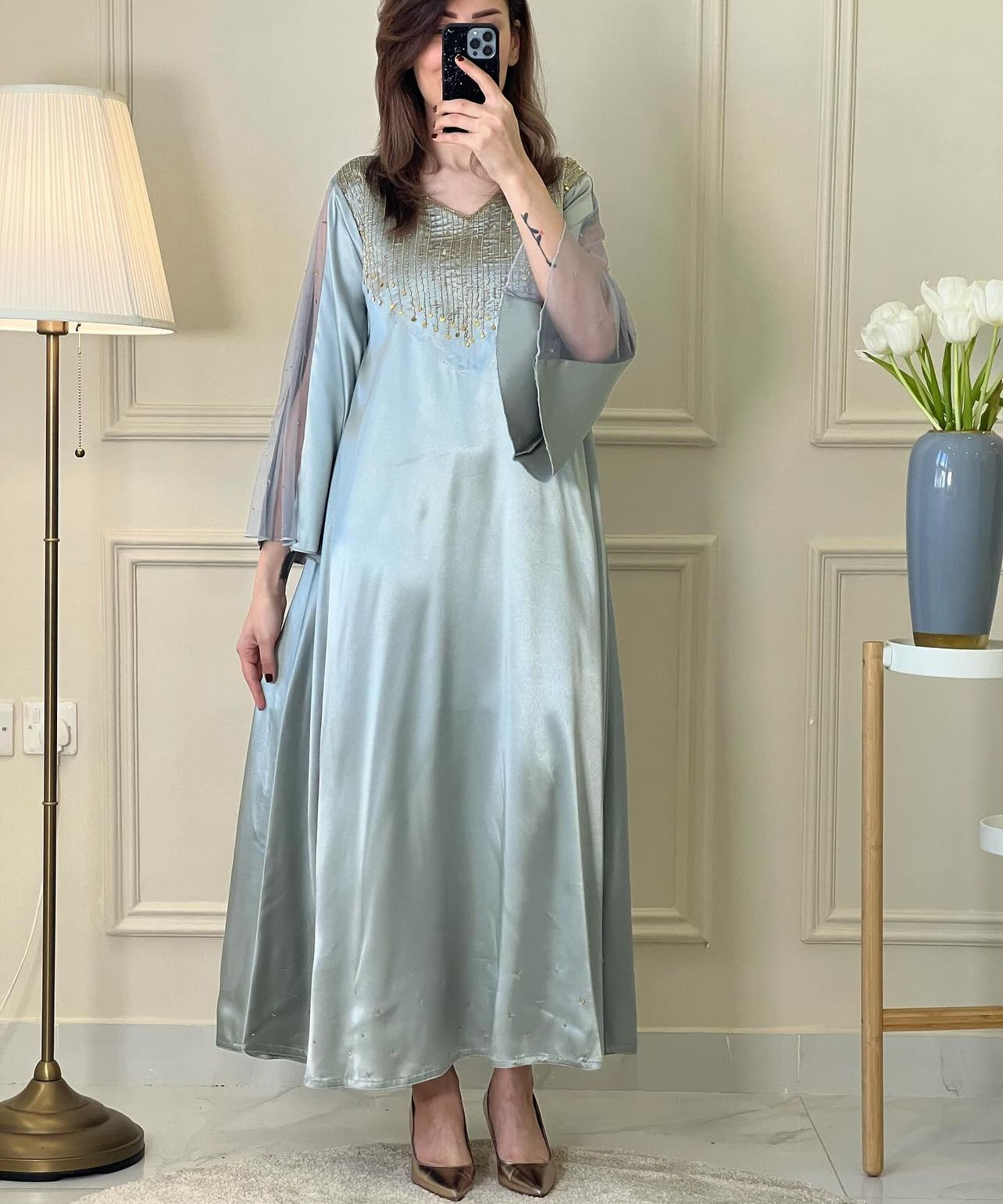 A woman wearing an ice blue satin embellished dress