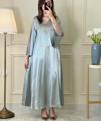 A woman wearing an ice blue satin embellished dress
