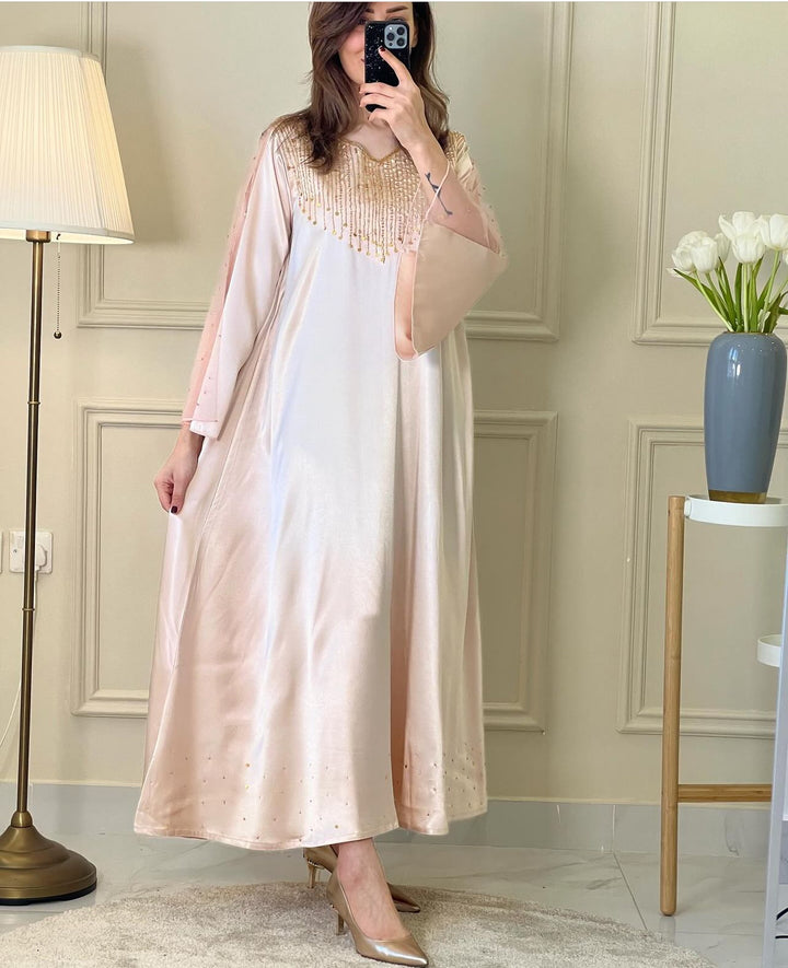 A woman wearing a Rose Gold Satin Embellished Dress