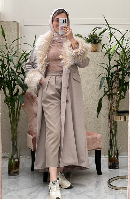 A Woman wearing a beige abaya with faux fur lining, paired with a matching Sheila headscarf