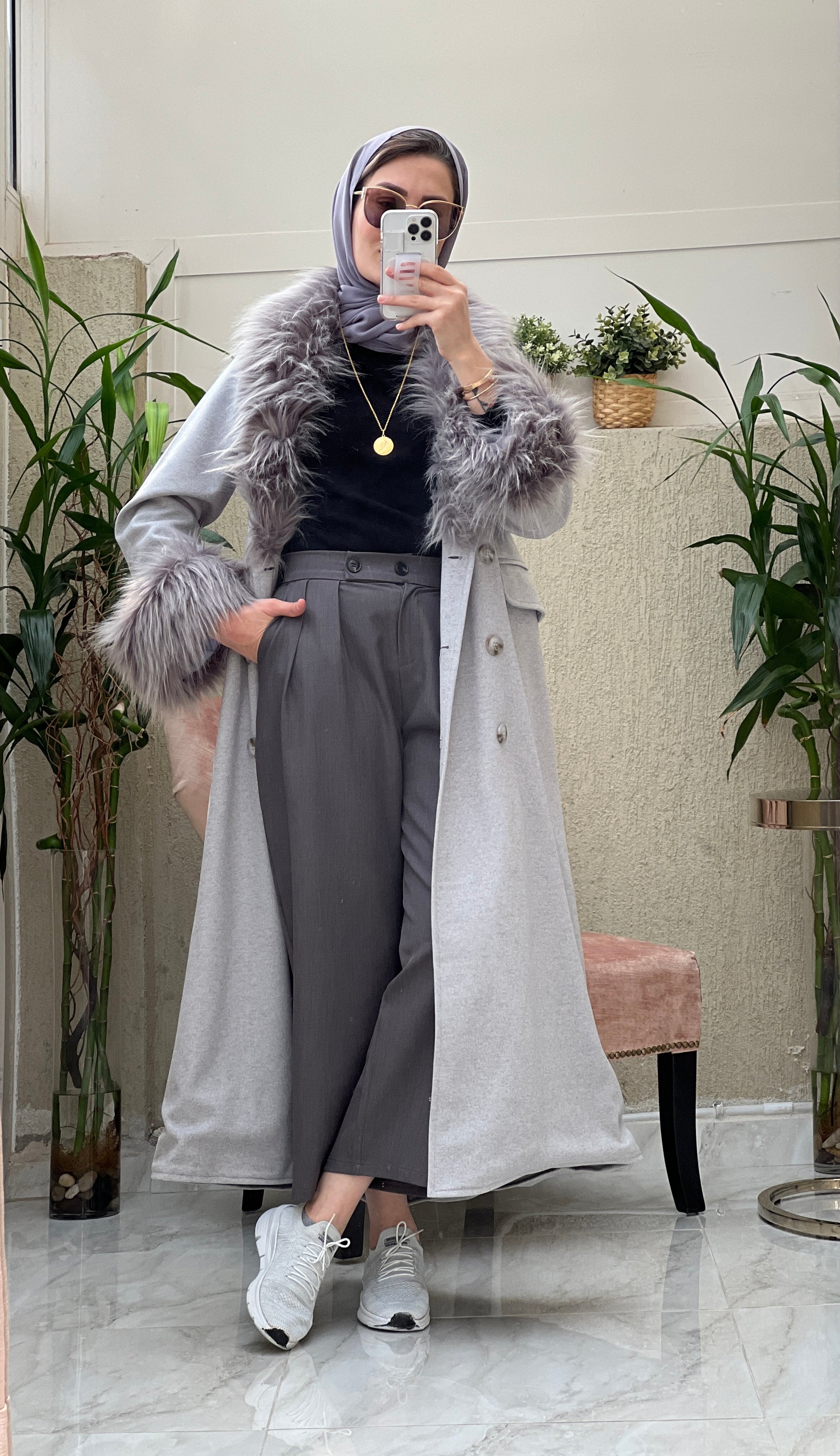 A Woman wearing a Grey abaya with faux fur lining, paired with a matching Sheila headscarf