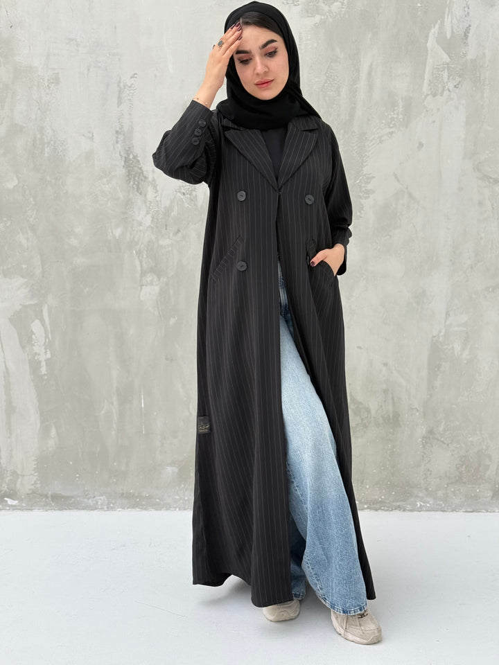 A woman wearing a Black Pinstripe Linen Coat Abaya with a striped pattern, featuring a hood and button-down front.
