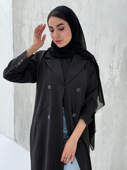 A woman wearing a Black Pinstripe Linen Coat Abaya with a striped pattern, featuring a hood and button-down front.