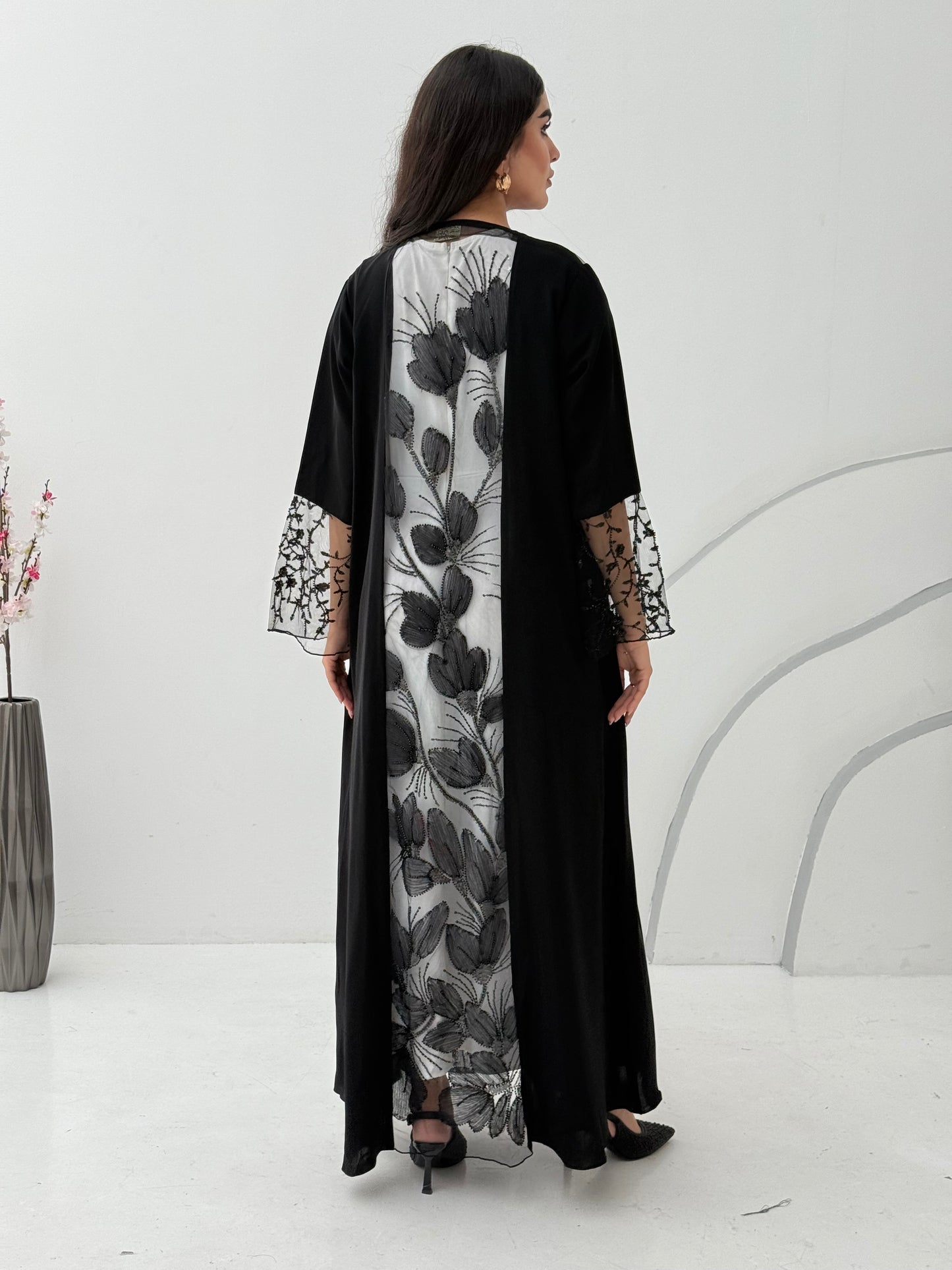 Woman wearing a Black Floral Lace Panel Abaya with a matching sheila against a white background