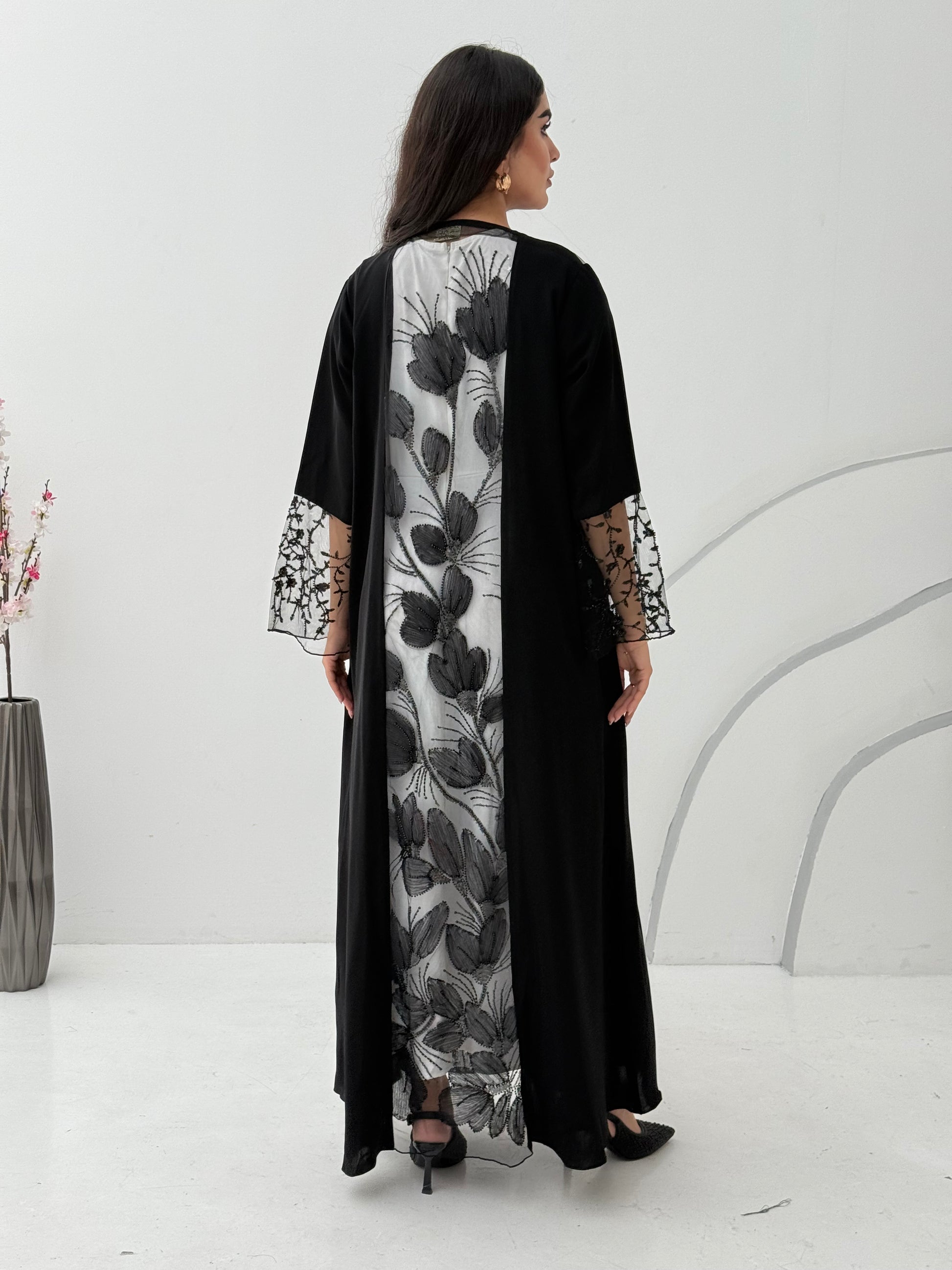 Woman wearing a Black Floral Lace Panel Abaya with a matching sheila against a white background
