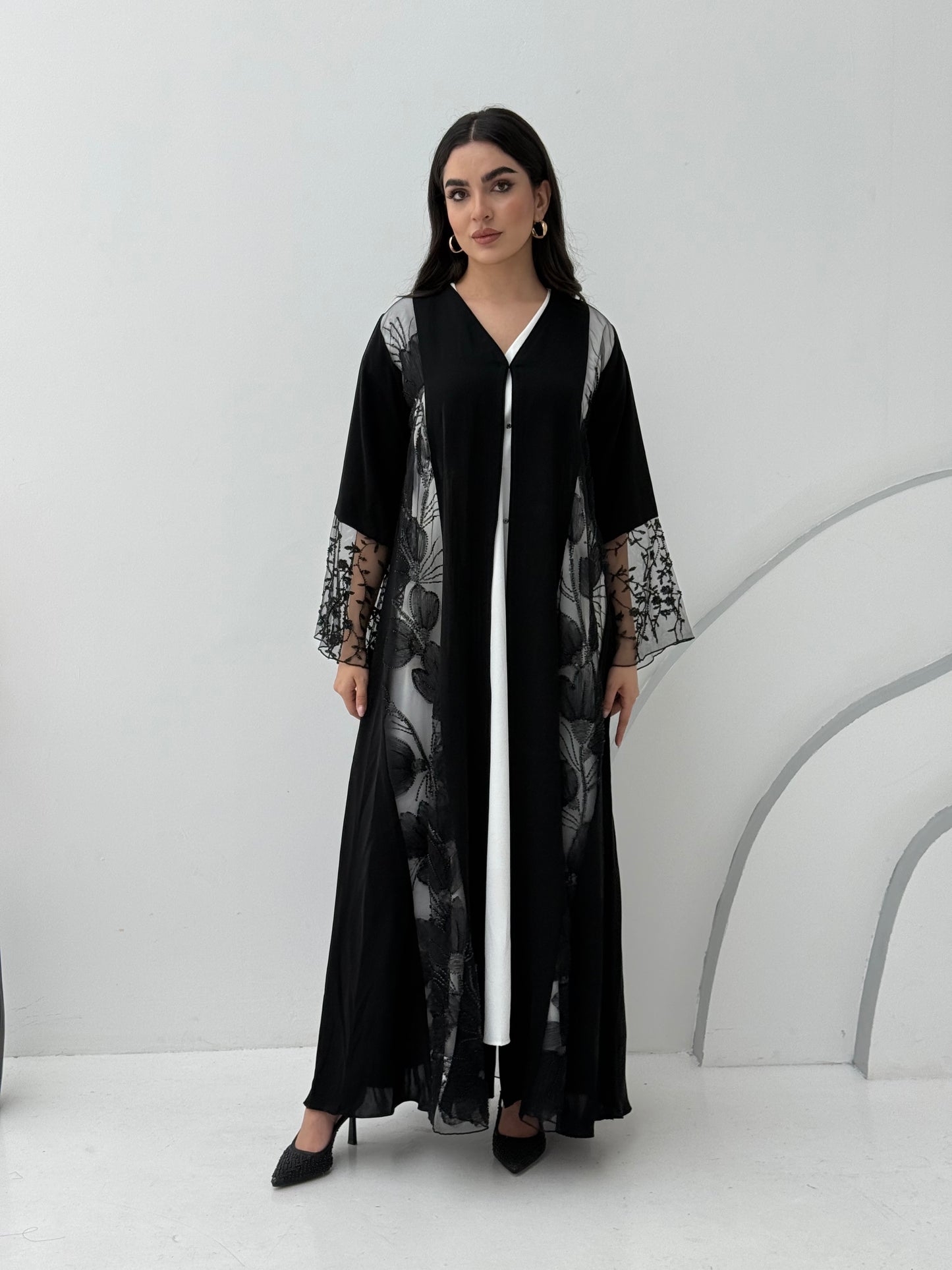 Woman wearing a Black Floral Lace Panel Abaya with a matching sheila against a white background