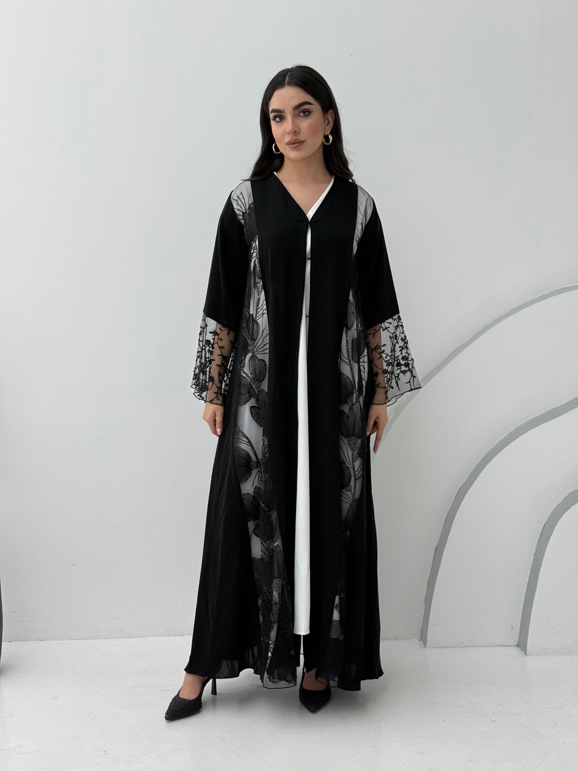 Woman wearing a Black Floral Lace Panel Abaya with a matching sheila against a white background