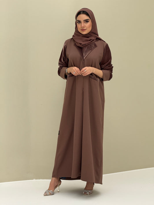 A woman wearing a chocolate brown abaya with velvet and barbei fabric, posing against a neutral background.