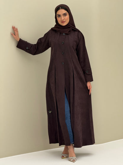 A woman wearing a dark brown Ice Cool Coat style with round neck and panel details Button-front, vertical bodice seams, buttoned cuff tabs
