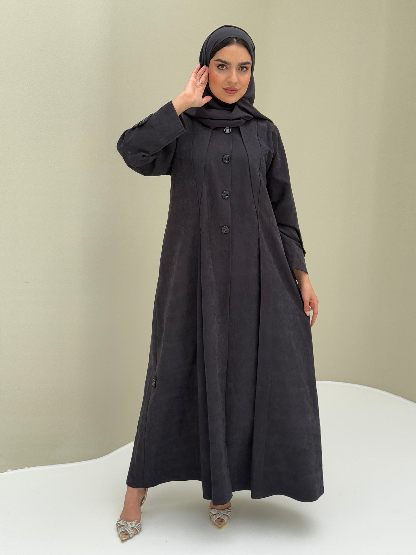 A woman wearing a dark grey Ice Cool Coat style with round neck and panel details Button-front, vertical bodice seams, buttoned cuff tabs