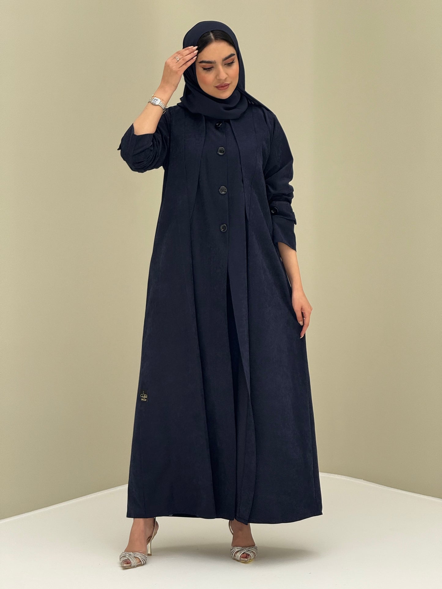 A woman wearing a Navy Blue Ice Cool Coat style with round neck and panel details Button-front, vertical bodice seams, buttoned cuff tabs