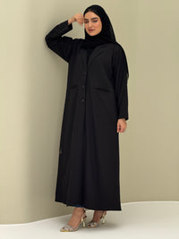 A woman wearing a black Coat style with a lapel collar, Button-front, welt pockets, buttoned cuffs, and a matching sheila