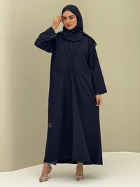 A woman wearing a navy blue Coat style with a lapel collar, Button-front, welt pockets, buttoned cuffs, and a matching sheila