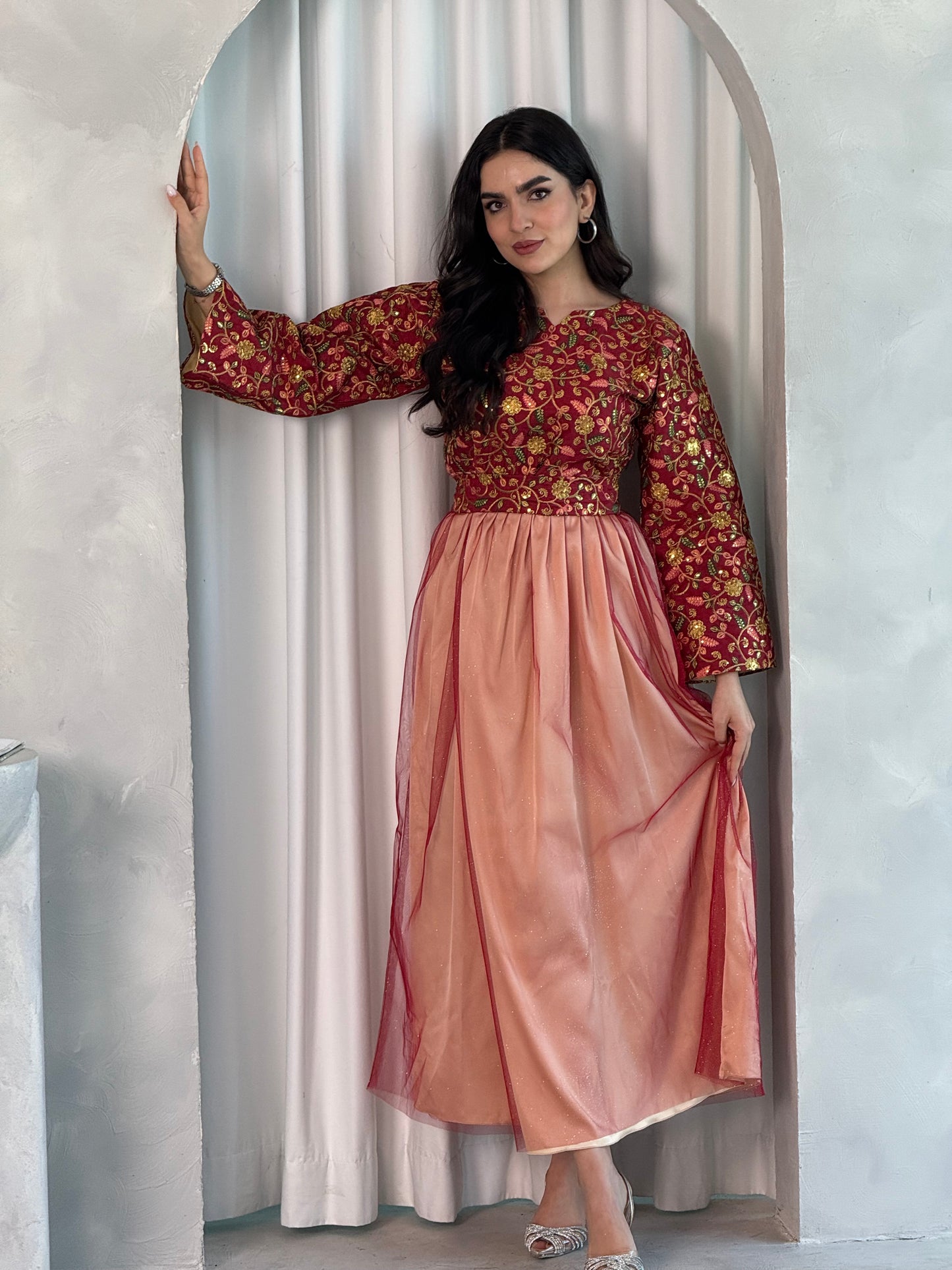 A woman wearing a floral long-sleeve Red & Peach Embroidered Tulle Dress