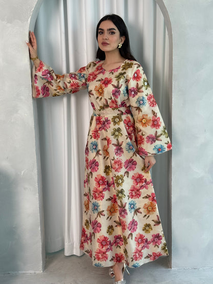 A woman wearing a cream Floral Print Organza with Sequin Embroidery dress with long sleeves and a round neckline.