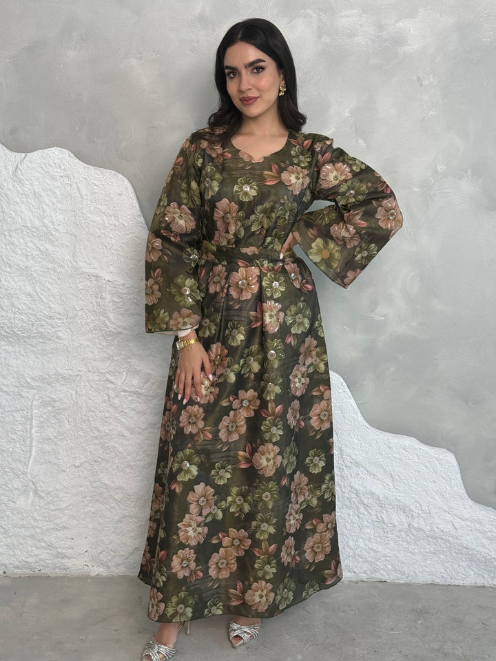 A woman wearing a dark olive green Floral Print Organza with Sequin Embroidery dress with long sleeves and a round neckline.
