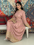 A woman seated on a bench against a colorful, patterned backdrop, wearing a dusty pink A-line Jalabiya with wide sleeves with gold embroidered details and long sleeves.