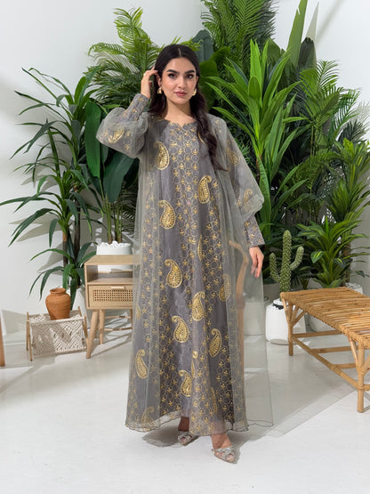 A woman seated in a garden setting, wearing an A-line grey Paisley Dress with Bishop Sleeves with gold embroidery and a netted veil.