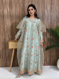 A woman standing in an indoor setting, wearing a light blue dress with Pink floral embroidery, gold vine patterns, wide, draped sleeves, and a satin base with a Sheer Net Overlay.