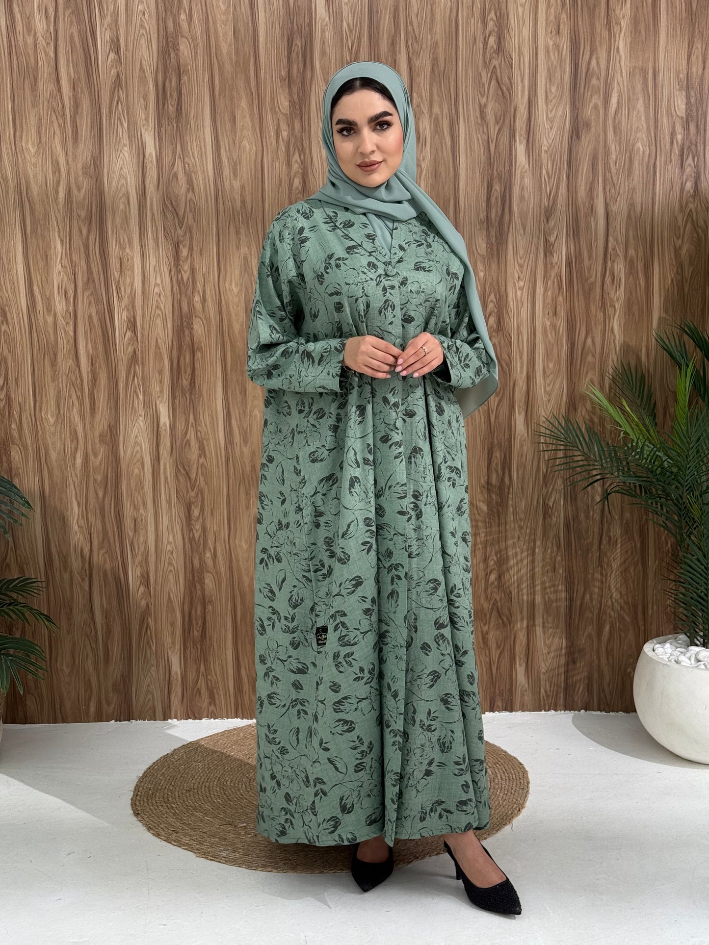 A sage green floral abaya that is perfect for office, evening wear, and events.