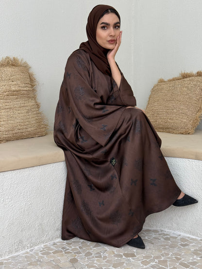 A stunning chocolate brown butterfly abaya with a satin floral print, that is perfect choice for evening gatherings or  stylish daytime wear.
