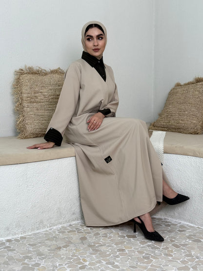 A layered beige abaya of a linen fabric hat is perfectly suited for daytime meetings or casual outings and travel.