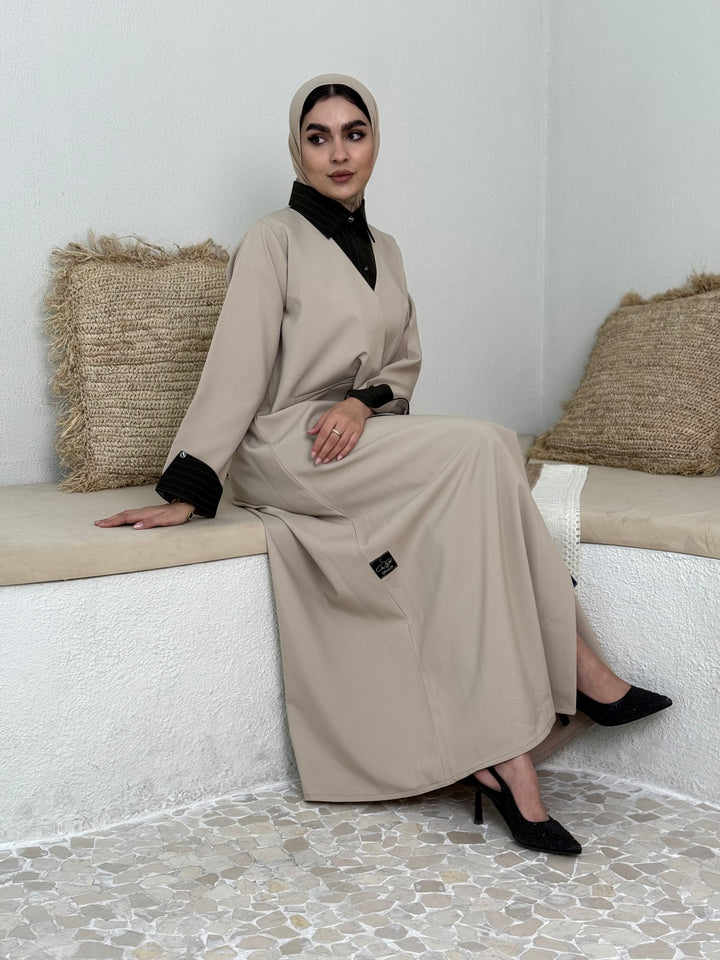A layered beige abaya of a linen fabric hat is perfectly suited for daytime meetings or casual outings and travel.