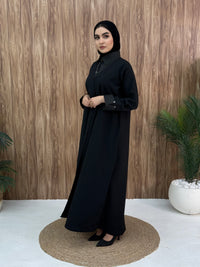 A layered black abaya of a linen fabric hat is perfectly suited for daytime meetings or casual outings and travel.