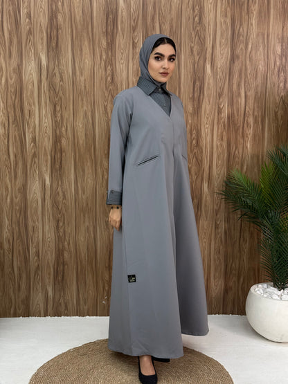 A layered light grey abaya of a linen fabric hat is perfectly suited for daytime meetings or casual outings and travel.