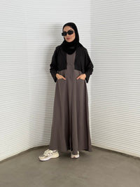 A black and brown abaya, tailored from Linen, it features a coat-style collar and pockets for a structured fit.