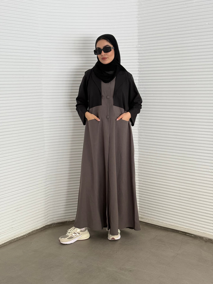 A black and brown abaya, tailored from Linen, it features a coat-style collar and pockets for a structured fit.