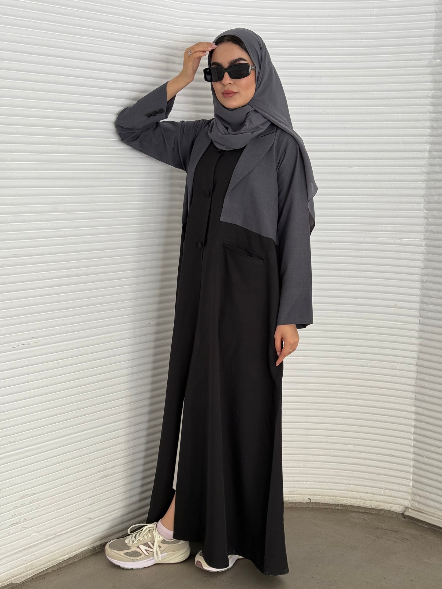 A black and grey abaya, tailored from Linen, it features a coat-style collar and pockets for a structured fit.