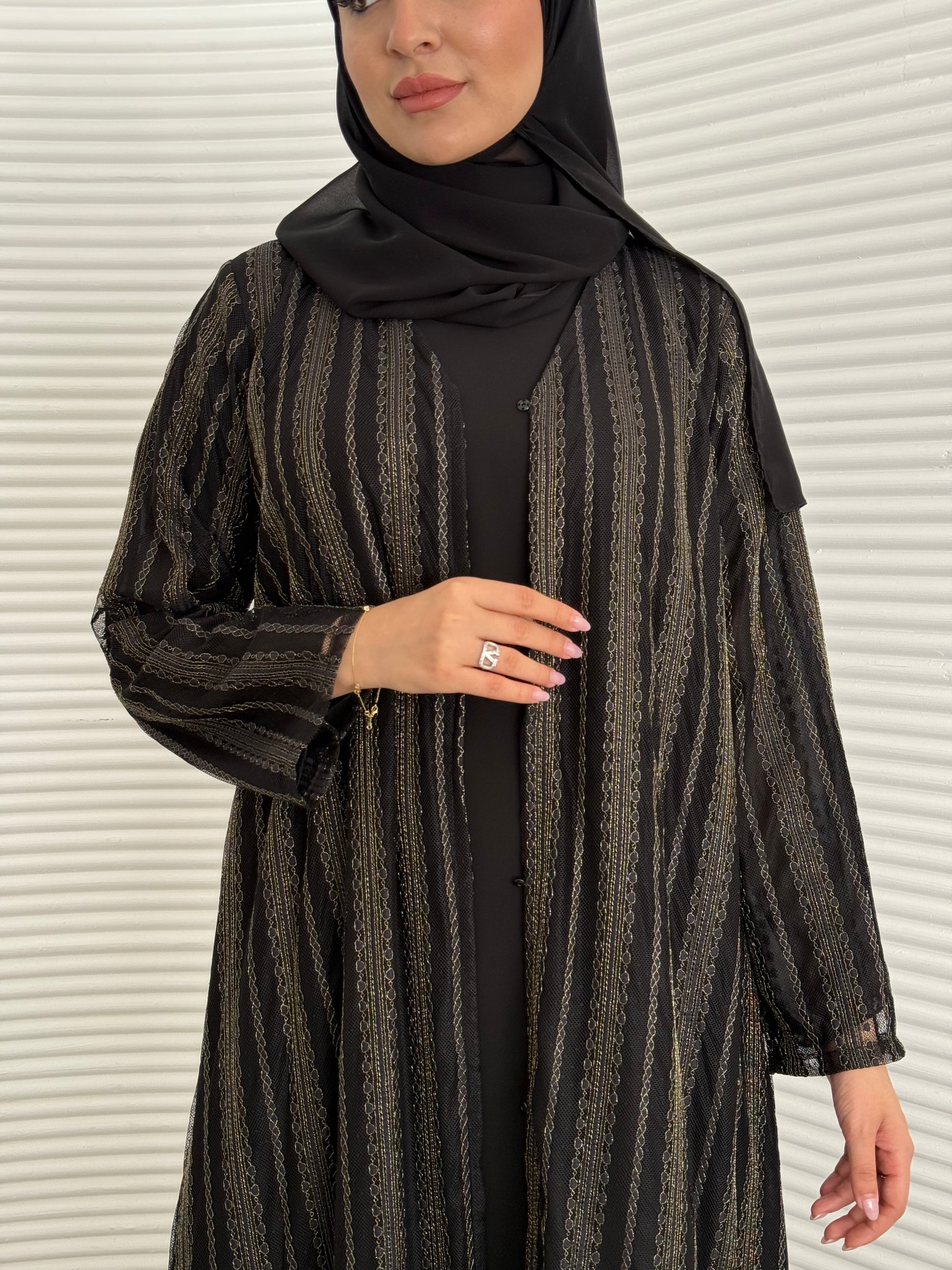 A 3 set of black and gold abaya, that includes a matching inner dress and sheila, this set is perfect for effortless evening luxury.