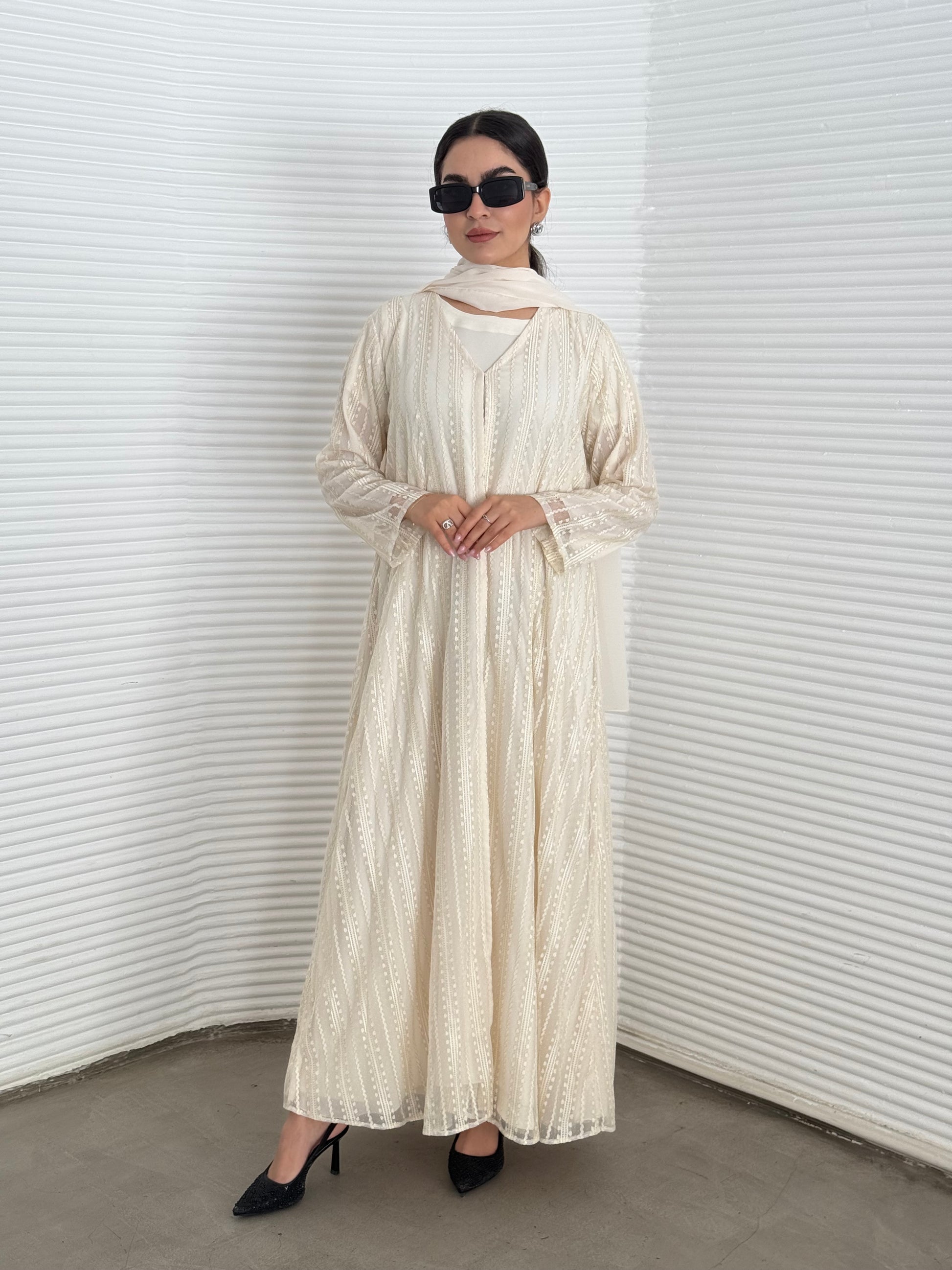 A 3 set of cream abaya, that includes a matching inner dress and sheila, this set is perfect for effortless evening luxury.