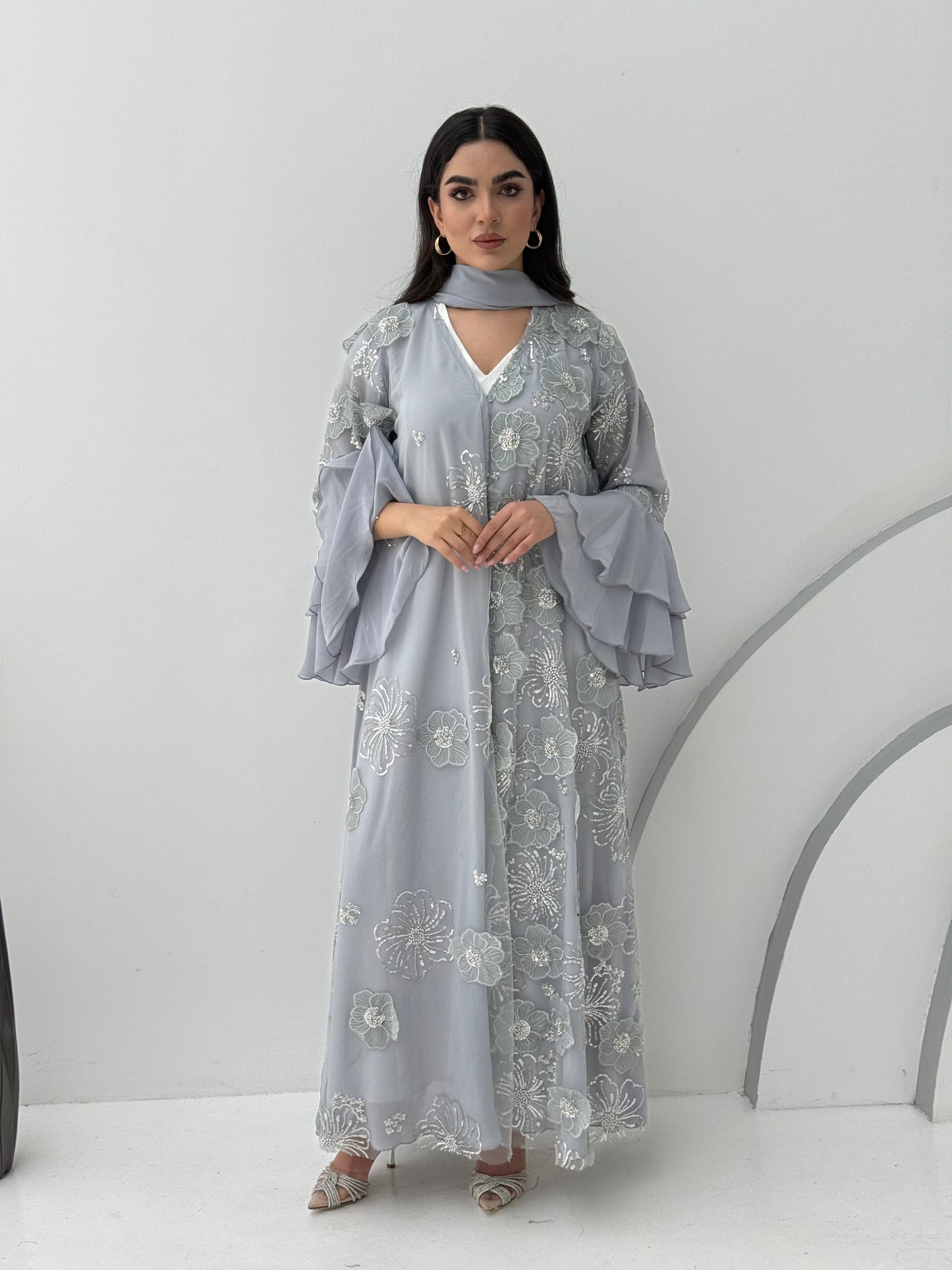 A luxurious light grey abaya with chiffon and texture of Black floral lace. This abaya is perfect for evening outings and occasions.